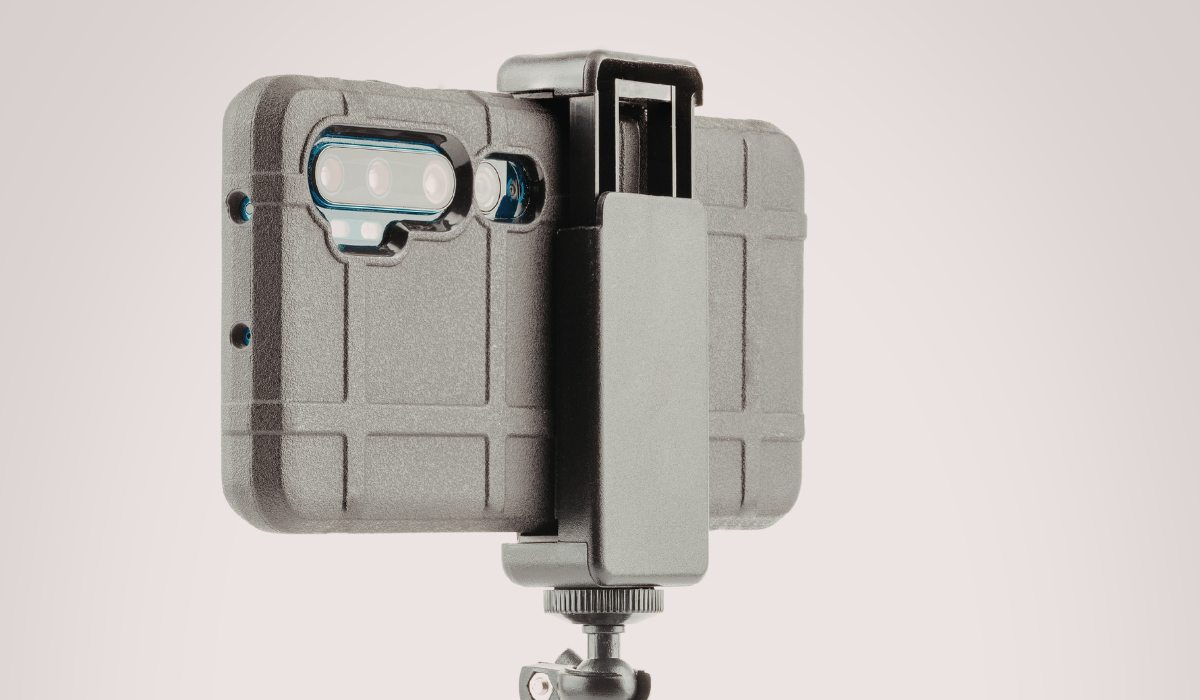 Técnico inspeccionando la lente de una cámara móvil empañada bajo microscopio para detectar residuos minerales