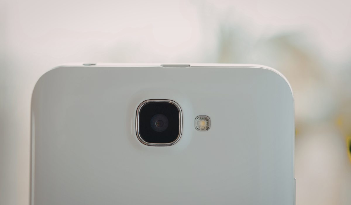 Técnico inspeccionando un módulo de cámara con OIS dañado bajo microscopio