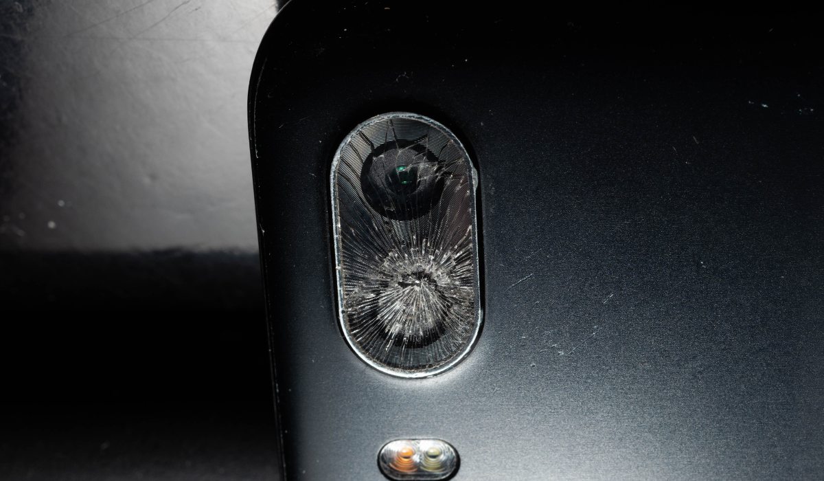 Técnico retirando fragmentos de cristal de cámara con pinzas de precisión bajo microscopio