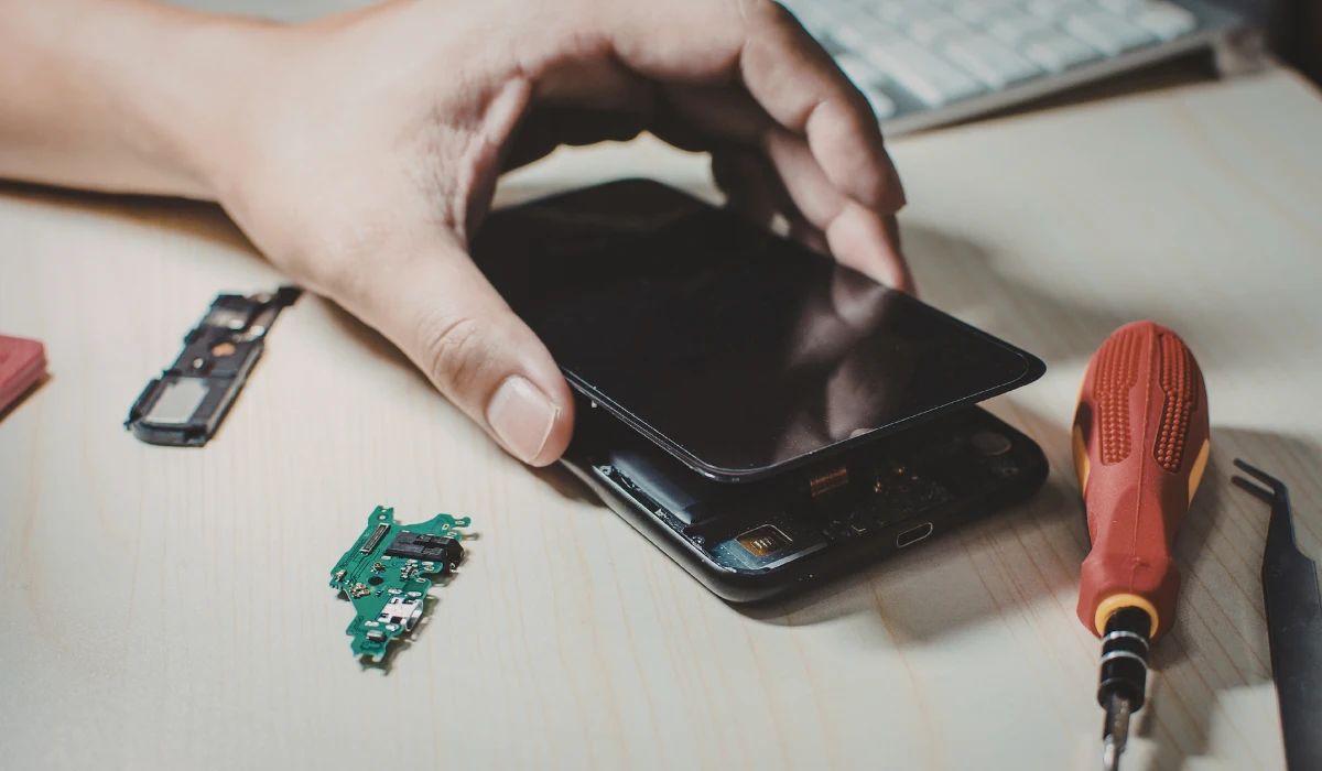 Técnico comparando dos pantallas bajo luz ultravioleta para detectar sellos de autenticidad y calidad de materiales