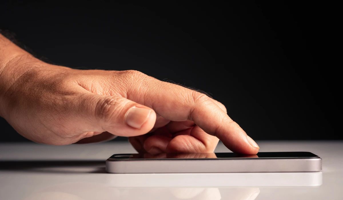 Técnico separando las capas de una pantalla OLED utilizando hilo de molibdeno y plancha de calor