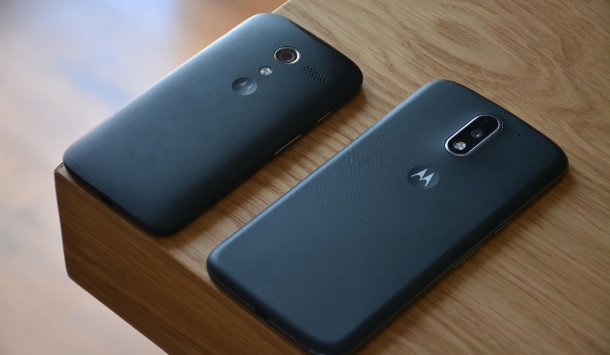 Técnico sustituyendo una placa auxiliar de carga en un Motorola Moto G con herramientas de precisión