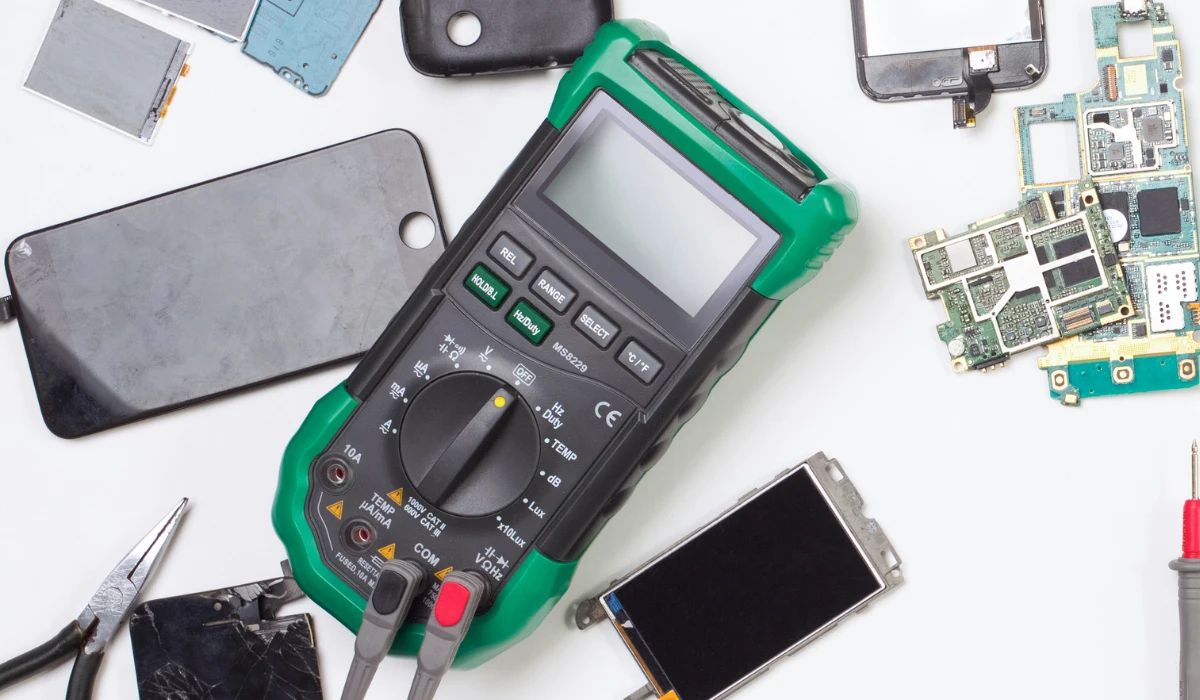 Técnico midiendo voltajes en una placa base de smartphone bajo microscopio con puntas de aguja extra finas