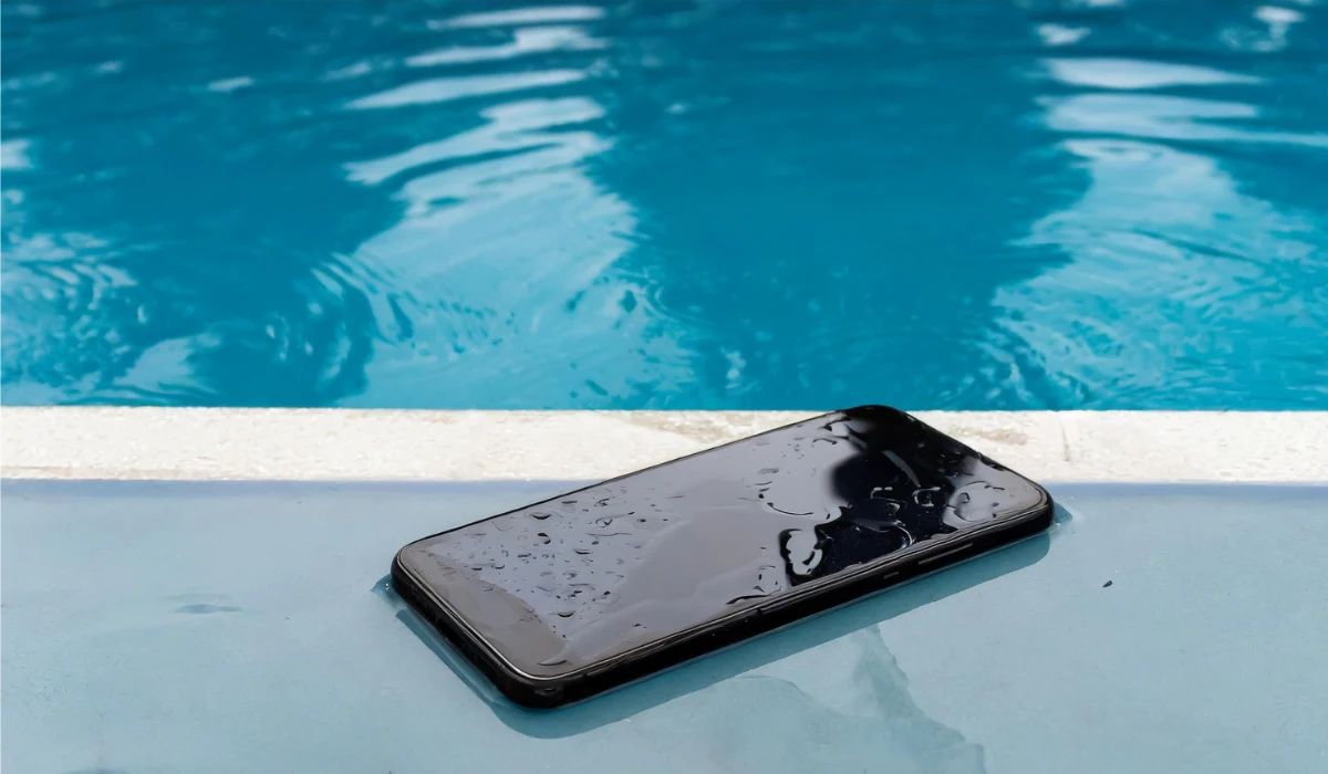 Técnico realizando limpieza química de una placa base mojada para eliminar la sulfatación bajo microscopio