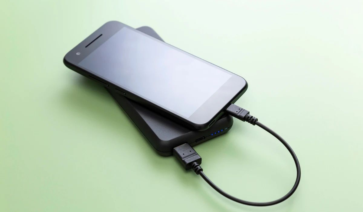 Técnico inspeccionando puerto USB-C obstruido con microscopio digital para limpieza de precisión