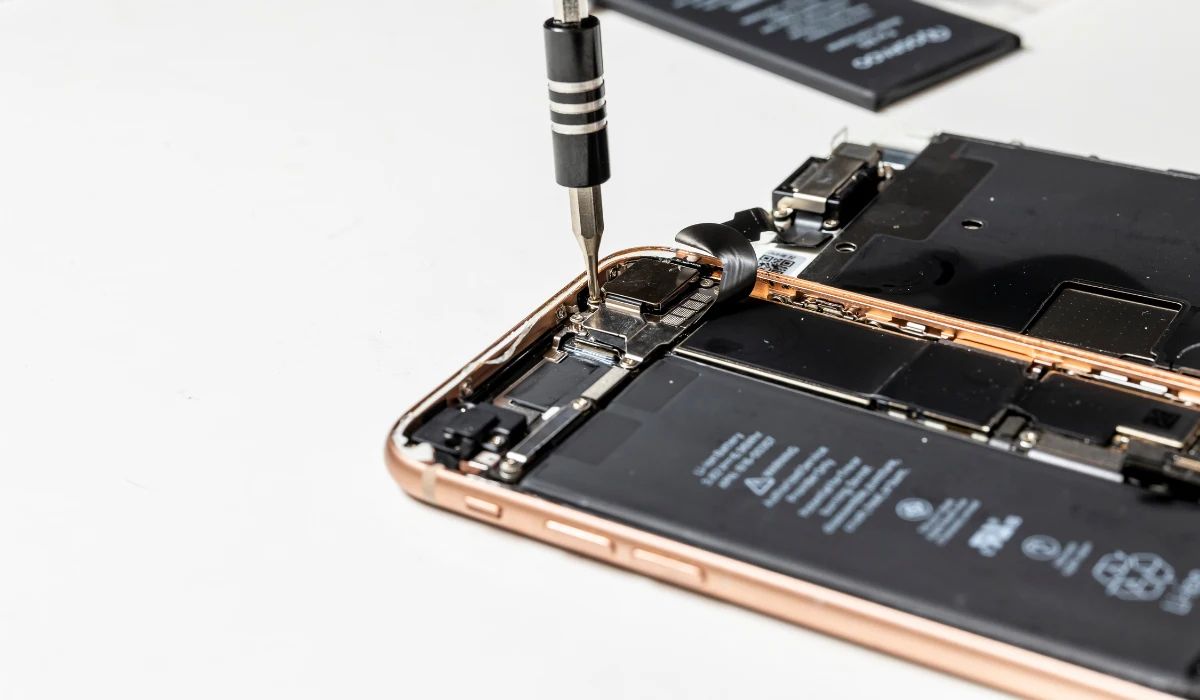 Técnico profesional realizando microsoldadura en el flex de una batería de iPhone para trasplantar el chip BMS