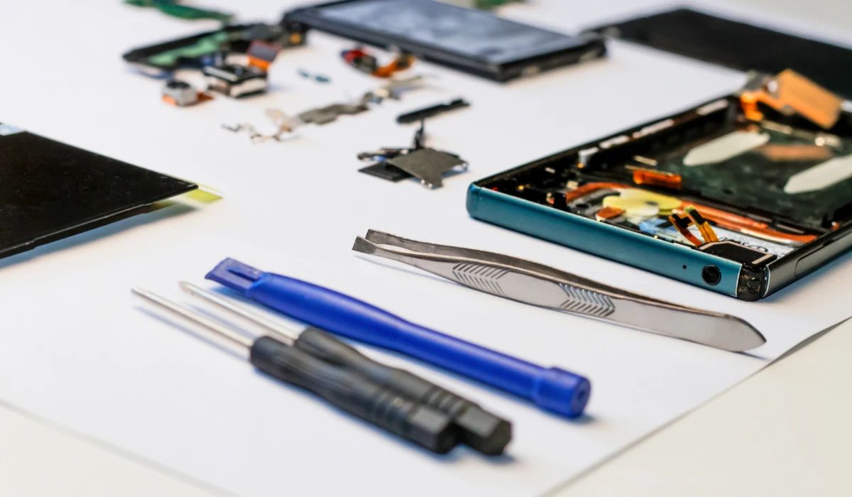 Técnico comparando un flex de pantalla original con uno compatible bajo el microscopio